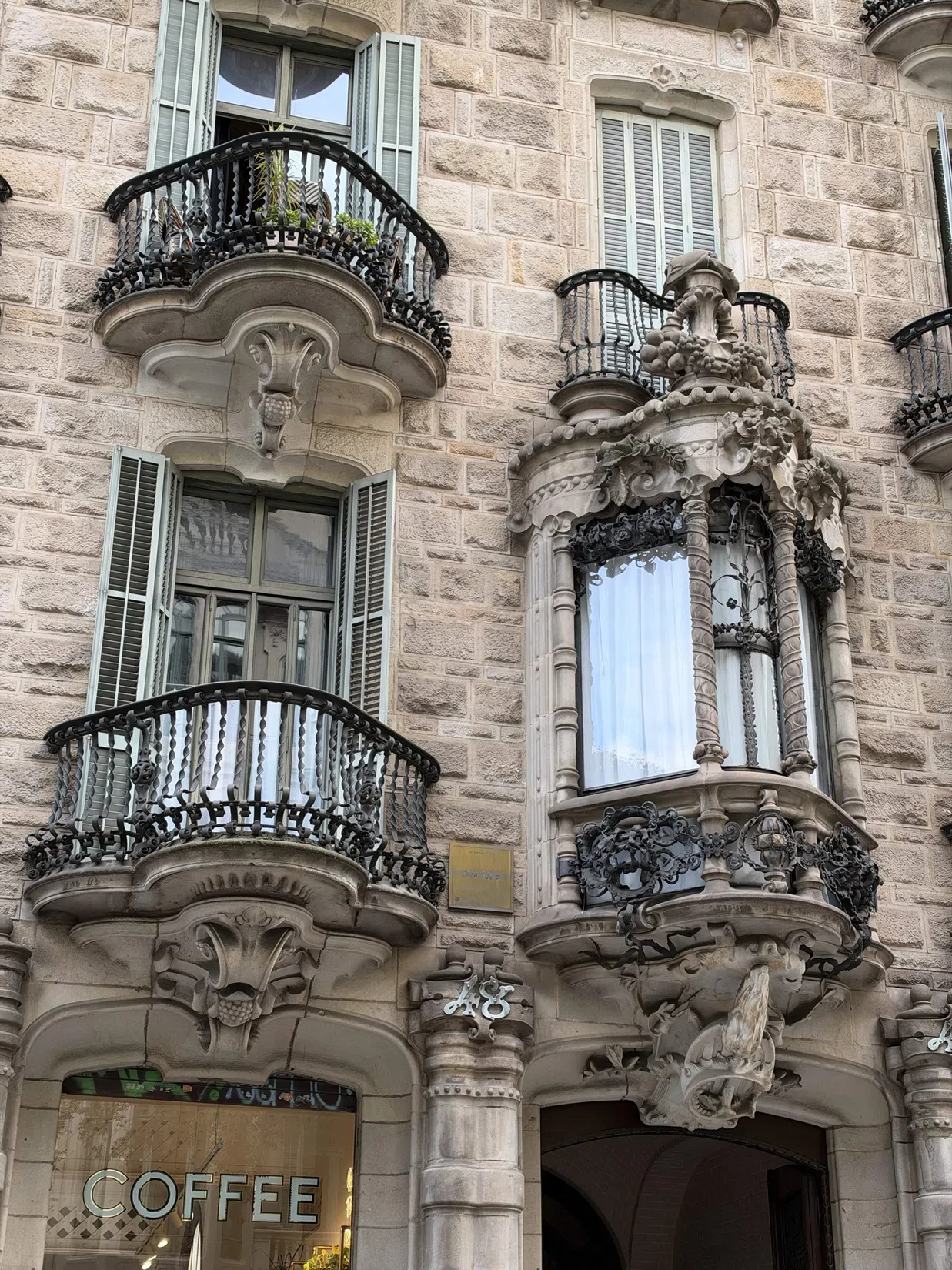 Stonework and wrought-iron detail in the first photographed façade   |   11:11